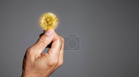 Foto de La mano del anciano sostiene una moneda de oro Bitcoin. El dinero criptomoneda Confianza financiera de los ancianos después del concepto de jubilación. - Imagen libre de derechos