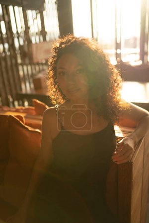 Photo for Portrait of a curly woman sitting in backlit. High quality photo - Royalty Free Image