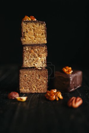 Cut halva in chocolate at dark background with nuts. High quality photo