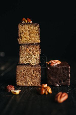 Cut halva in chocolate at dark background with nuts. High quality photo