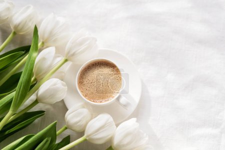 Photo for Cozy morning coffee cup with white tulip flowers from above, breakfast on Mothers day or Womens day. Top view with copy space Floral composition Romantic background - Royalty Free Image