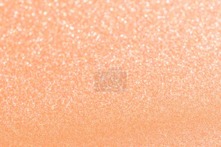 Color of the Year 2024 Peach Fuzz Abstract background. Glitter texture christmas background. Defocused abstract holidays lights on background.