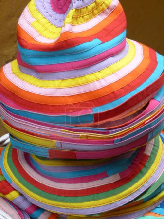 Téléchargez les photos : Une pile de chapeaux colorés dans un étal de marché - en image libre de droit