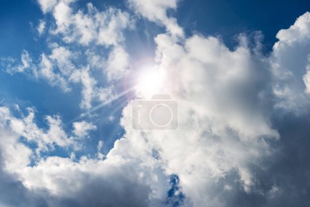 Foto de Hermoso cielo azul con nubes de cúmulos blancos y rayos de sol (rayos de sol). Fotografía retroiluminada. - Imagen libre de derechos