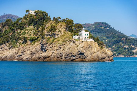 Headland and white lighthouse of Portofino village, Genoa province (Genova), Liguria, Italy, Europe. Rocky coast of the Mediterranean Sea (Ligurian Sea).