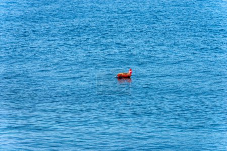 Téléchargez les photos : Bouée de sécurité de plongée rouge et orange et drapeau dans la mer bleue. Mer Méditerranée, Golfe de La spezia, Ligurie, Italie, Europe. - en image libre de droit