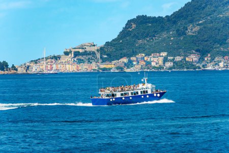 Photo for Tour boat or ferry with many tourists in motion in the Gulf of La Spezia to the Cinque Terre, Porto Venere or Portovenere town and Palmaria island, Liguria, Italy, Europe. - Royalty Free Image