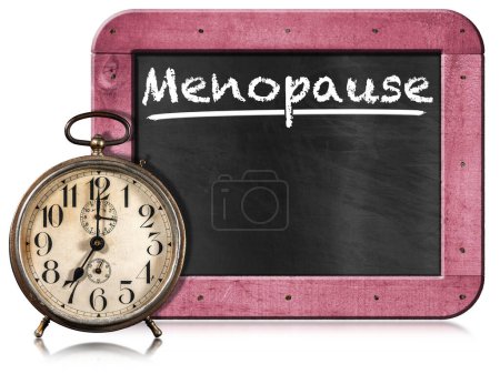 Closeup of an old alarm clock and a blackboard with text Menopause, pink wooden frame and copy space. Isolated on white background.