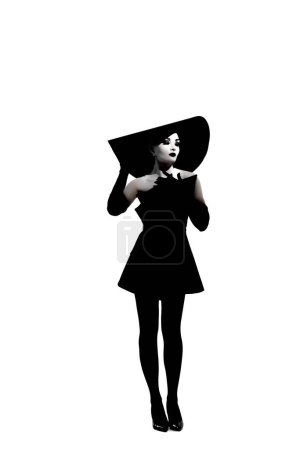 Foto de Mujer joven con maquillaje en la cara posa en el estudio con elegante sombrero de ala ancha, vestido negro y guantes sobre fondo blanco. Imagen aislada. - Imagen libre de derechos