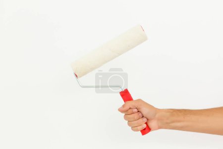 Photo for Woman hand holding a paint roller isolated on a white background. - Royalty Free Image