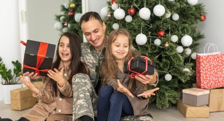 Téléchargez les photos : Military father and children near christmas tree. - en image libre de droit