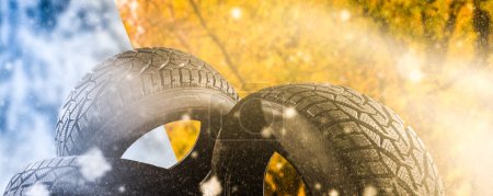 Stapel neuer schwarzer Reifen für winterliches Autofahren isoliert auf farbigem Hintergrund.