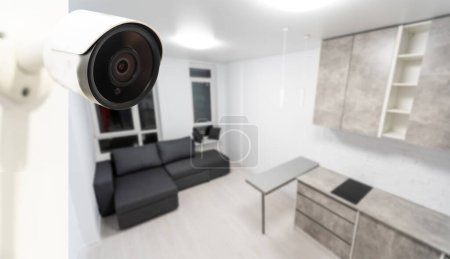 Foto de Primer plano Fotografía de un objeto de una cámara de vigilancia Wi-Fi moderna en una pared blanca en un acogedor apartamento tiene icono Wi-Fi por encima de ella - Imagen libre de derechos
