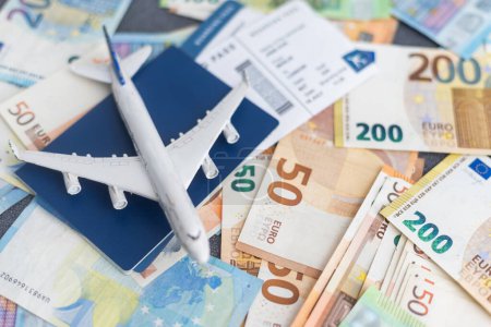 Avion jouet sur fond de cash Euro, voyage en avion. Image conceptuelle du prix des billets d'avion pour les voyages. Focalisation sélective, gros plan