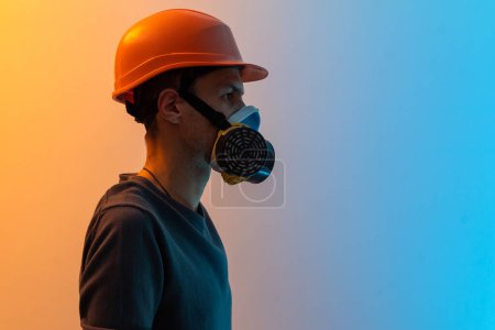 Foto de Un hombre en una máscara con un filtro y un fondo de color casco. - Imagen libre de derechos