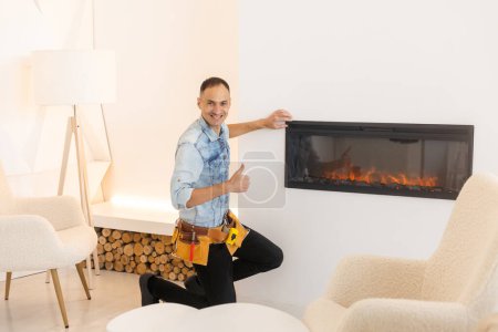 Photo for Professional technician installing electric fireplace in room. - Royalty Free Image
