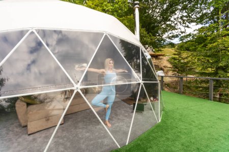Téléchargez les photos : A woman is in a geo dome glamping tent. Glamping vacation lifestyle concept - en image libre de droit