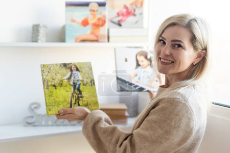 Junge Frau hängt ein Gemälde mit Fotoleinwand an die Wand.