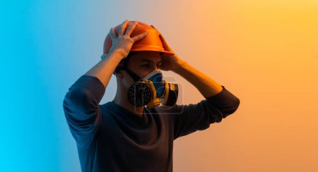 Foto de Un hombre en una máscara con un filtro y un fondo de color casco. - Imagen libre de derechos