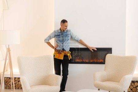 Photo for Professional technician installing electric fireplace in room. - Royalty Free Image