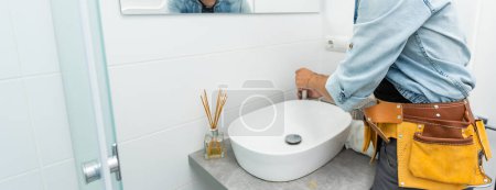 Photo for Plumber installs a new faucet for a sink. - Royalty Free Image
