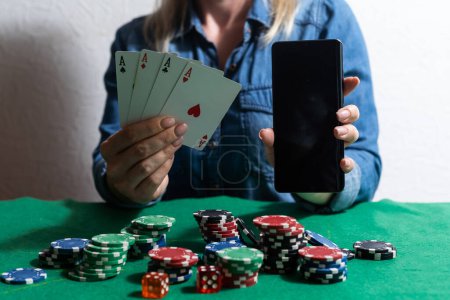Photo for The concept of an online casino: playing cards, betting chips and a smartphone with a copy space in womens hands. Top view. - Royalty Free Image