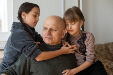 Téléchargez les photos : Grand-père ukrainien et deux petites-filles câlins. - en image libre de droit