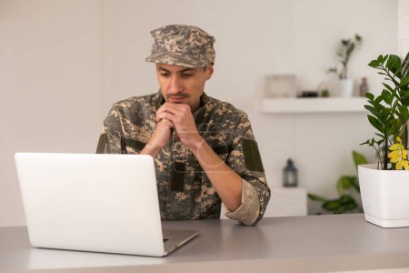 Foto de Joven soldado militar hombre retrato con portátil en el fondo - Imagen libre de derechos
