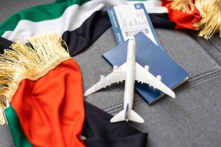 Pasaporte y bandera de los Emiratos Árabes Unidos sobre fondo gris. Concepto de viaje.