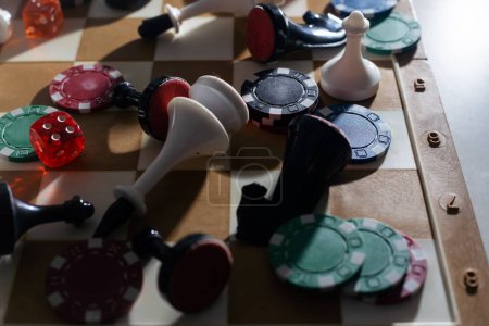 Téléchargez les photos : Dames en bois, pièces d'échecs, cartes à jouer, jeux de société sur une table lumineuse close up - en image libre de droit