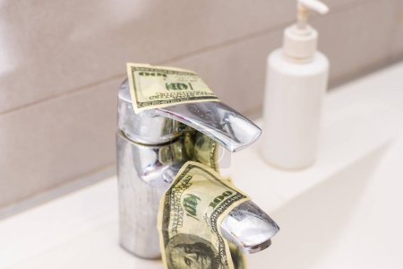 Foto de Dinero en efectivo que baja el drenaje del fregadero aislado sobre fondo blanco
. - Imagen libre de derechos