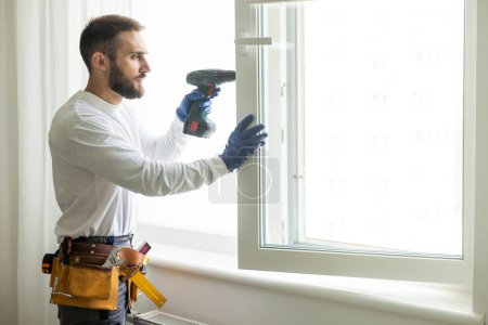 Foto de Hombre de servicio instalando ventana con destornillador. - Imagen libre de derechos
