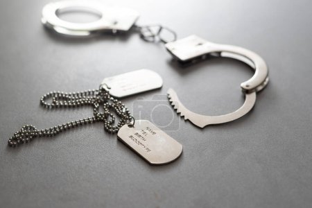 Photo for A military badge and handcuffs on a dark background. - Royalty Free Image