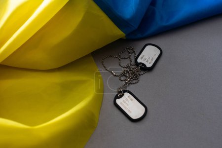 Photo for Army identification badges, ribbons of the Ukrainian flag, scattered machine-gun cartridges and live ammunition on a white background. Concept: war in Ukraine, military special operation, conscription - Royalty Free Image