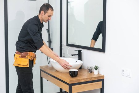 Téléchargez les photos : Hommes fixer un évier dans la salle de bain. - en image libre de droit