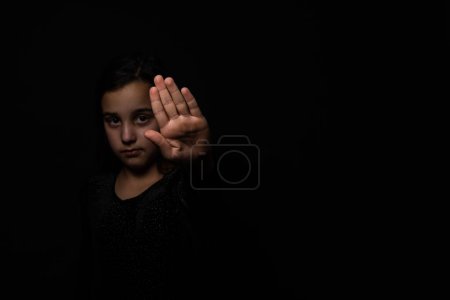 Foto de Kid girl showing hand signaling to stop useful to campaign against violence and pain. Stop abusing violence. violence, terrified , A fearful child, human rights day concept. copy space - Imagen libre de derechos