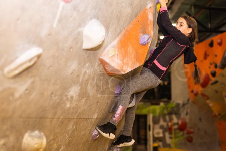 Téléchargez les photos : Youngsters effort in climbing a wall to reach the top - en image libre de droit