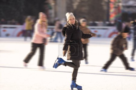 Téléchargez les photos : Joyeux sourire femme patin à roulettes patinoire coucher de soleil d'hiver - en image libre de droit