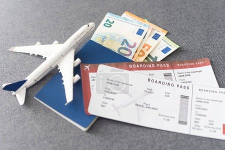 Foto de Pasaportes, tarjetas de embarque y aviones de juguete sobre mesa gris. - Imagen libre de derechos