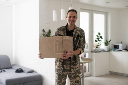 Foto de Soldier Holding Shipping Box. military man with a box. - Imagen libre de derechos