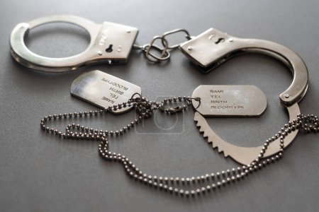 Photo for A military badge and handcuffs on a dark background. - Royalty Free Image