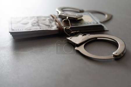 Photo for Handcuffs and one hundred dollars on the wooden table. - Royalty Free Image