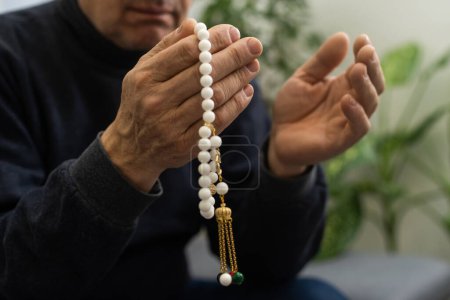 Téléchargez les photos : Les mains priantes d'un vieil homme tenant des perles de chapelet - en image libre de droit