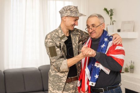 Photo for An elderly father and a military son saluting American flag. - Royalty Free Image