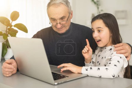 Photo for Grandfather and granddaughter spend time together use laptop, browse website, younger generation teach explain to older how to use modern tech concept. - Royalty Free Image