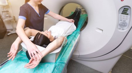 Una mujer yace en la mesa del tomógrafo. mujer se somete a tomografía axial computarizada en un hospital moderno.