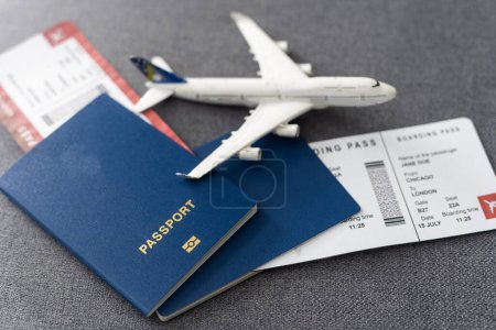 Foto de Pasaportes, tarjetas de embarque y aviones de juguete sobre mesa gris. - Imagen libre de derechos