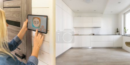 Foto de Mujer usando el sistema de control del hogar de pared inteligente. - Imagen libre de derechos