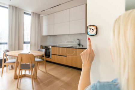 Termostato interior inteligente del hogar en el sistema de casa para la temperatura. Invierno de calefacción de energía eficiente automatización digital de pantalla táctil dispositivo táctil de la mano para ajustar la calefacción en la sala de estar. Domótica IoT.