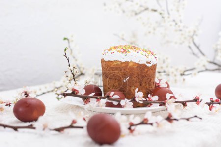 Téléchargez les photos : Gâteau de Pâques et œufs peints. Bouquet fleuri posé sur la table près de - en image libre de droit